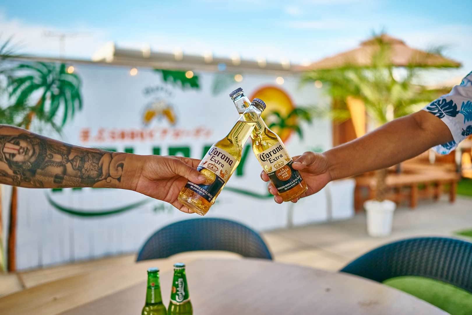 日差しの入るテラスで飲み物を合わせて乾杯する手元